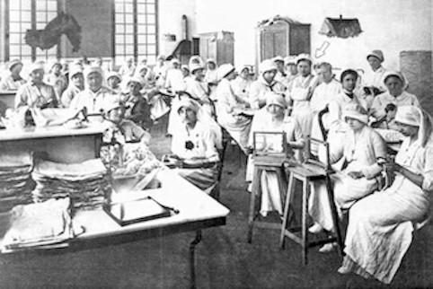 One of the halls of the bandage room at the American Hospital of Neuilly. Gassette is indicated by an arrow; her mother stands to her right. Chicago Tribune, July 25, 1915, p. 73. Newspapers.com