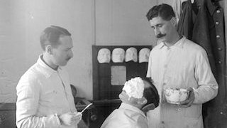 Photograph of Captain Francis Derwent Wood covering the face of a patient with plaster so as to make a mask which would conceal his injuries, 3rd London General Hospital. Imperial War Museum Collection Archives