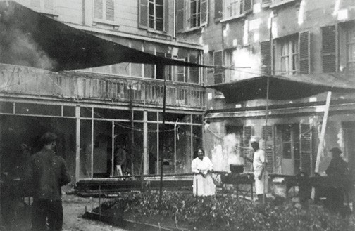 Photograph of the the construction workers preparing food in the courtyard of the rue de Chevreuse building, c. 1927. RH Archives.