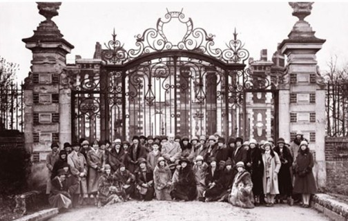 President William Allan Neilson, center, posed with the class of 1927 Juniors in Paris using the gates before the Chateau of Robecourt in Grécourt, France, as a backdrop. A reproduction of these gates had been cast in France and erected at the entrance to Smith College in 1924 in recognition of the service of the Smith College Relief Unit in France from 1917 to 1920. Photograph by Wide World Photos, Smith College Archives.