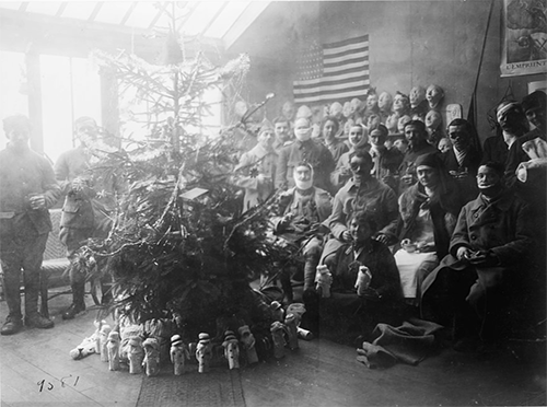 Mrs. Anna Coleman Ladd seated in the foreground surrounded by her patients at her studio, Christmas Day. 1918. Photograph. Library of Congress.