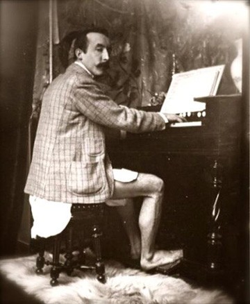 Gauguin playing the piano in his studio with Mucha